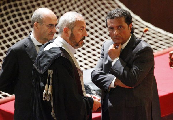 Schettino, captain of the Costa Concordia cruise ship, talks with his lawyers during a trial in Grosseto